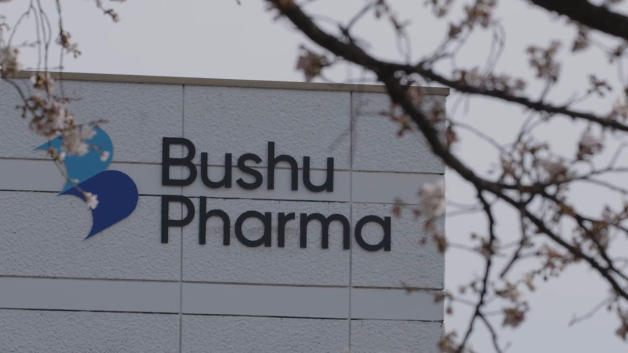 The Bushu Pharma logo on the side of their facility as seen from the ground.